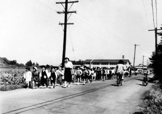 川崎街道を行く先生と子どもたち 昭和30年代 日野市郷土資料館提供